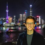 David Brenman, CESEAS alumnus, stands in front of Shanghai skyline at night