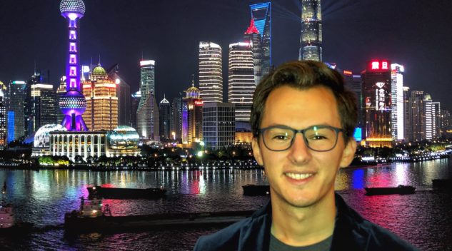 David Brenman, CESEAS alumnus, stands in front of Shanghai skyline at night