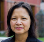 Professor Nhung Tran standing in the courtyard of the Munk School of Global Affairs.