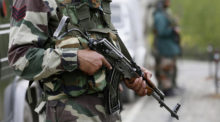 close up on the body of a soldier holding an automatic weapon.
