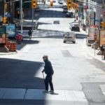 A pedestrian crosses an almost empty O'Connor Street in downtown Ottawa on May 14, 2020.