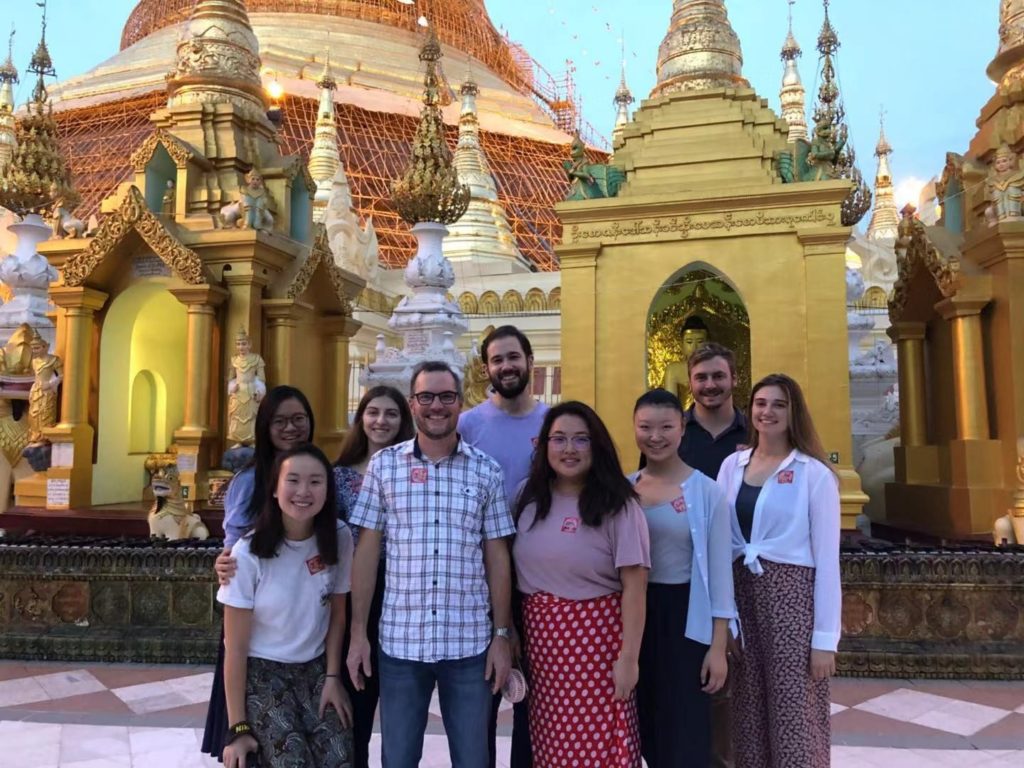 Photo of Angela with students and Professor in front of golden temple in Myanmar.