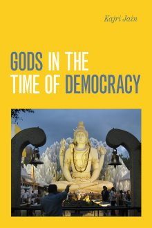 Book Cover: Gods in the Time of Democracy by Kajri Jain. Image of people standing below a tall god statue.