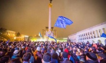 a Photo of a crowd on the Independence Square in Kiev including people waving flags of EU and Ukraine