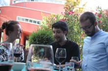 Karolina Dejnincka, Samuel Baird, and Peter Prazic talking over a glass of wine
