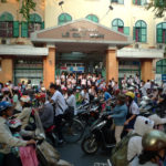 Crowd on scooters outside a school