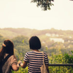 Two girls looking at green hills