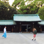Two people at a blue shrine and trees