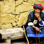 Old woman sitting with prayer beads