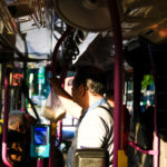 A man stands inside a bus.