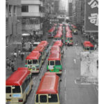 A street full of yellow buses with red roofs.