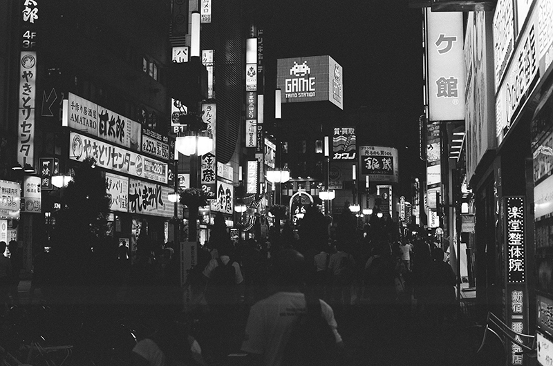 Photo in Andy Takagi’s “Summertime in Tokyo” series; the image shows neon lights lining the street in Shinjuku