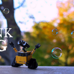 Wall-E with hands open and soap bubbles floating
