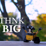 Image: 'Think Big' text with gleeful robot