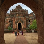 A traditional Myanmar captured through a long walkway and arch