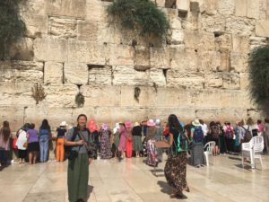 Student Stephanie Xu is standing in front of the Western Wall where many visitors are praying in front. The is an array of colour as various women wear different outfits. 