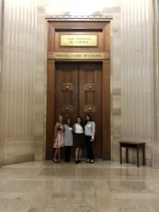 Four Munk One students stand and pose in front of a doorway