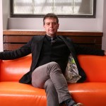 Ron Deibert sitting on an orange couch. Photo by Dave Chan.
