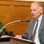 Ralph Nader stands speaking at a lectern.