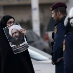 A Bahraini woman clashes with riot police after a protest