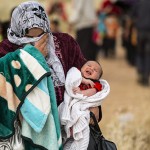A mother and child cross the border as they flee the Syrian civil war