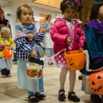 A group of children trick or treat at an indoor office