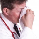 A doctor blows his nose.