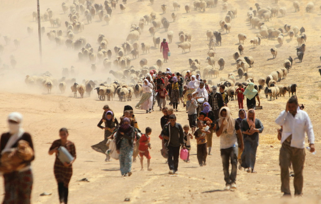 Displaced people from the minority Yazidi sect, fleeing violence from forces loyal to the Islamic State in Sinjar town, walk towards the Syrian border, August 2014. REUTERS/Rodi Said
