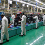 Employees work on an assembly line of Honda Motorcycle & Scooter India.