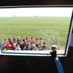 Children watch as a teacher puts on a puppet show inside a mobile education caravan.