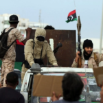 Armed Libyan men wave their national flags during a demonstration marking the fifth anniversary of the Libyan revolution.
