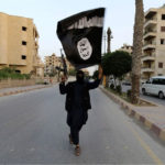 A member loyal to the Islamic State waves the group’s flag in the Syrian city of Raqqa.