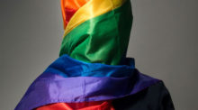 A woman wears a rainbow hijab.