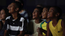 A group of children gather at a documentary screening.