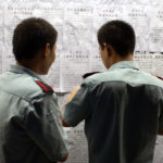 wo men post job advertisements on a job board for migrant workers in Shenzhen, China.