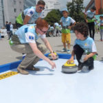 Peter Anderson is pictured teaching a child the basics of curling.