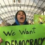 A group of protesters march with signs in Tehran.