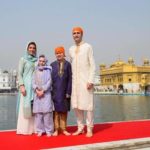 Justin Trudeau, dressed in a gold sherwani, poses with his wife and children.