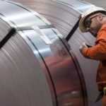 A Dofasco employee looks at rolls of coiled steel