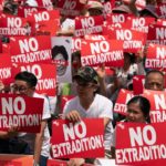 A group of protestors hold up 'no extradition signs'