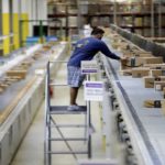 Man arranges boxes in an Amazon warehouse