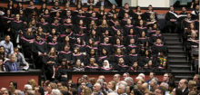 Group of graduates sit in convocation hall