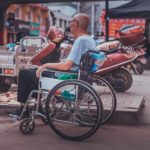 A man sits in a wheelchair at the market