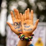 A pair of hands with "our lives are in your hands" written on the palms