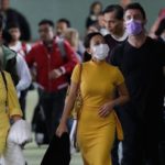 A group of people walk in public with surgical masks on