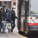 Passengers done masks as they board a TTC bus