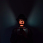 Man in dark room staring at his cell phone