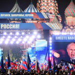 Russian President Vladimir Putin is seen on a screen set at Red Square as he addresses a rally and a concert marking the annexation of four regions of Ukraine in central Moscow on Sept. 30, 2022. AFP CONTRIBUTOR#AFP / AFP VIA GETTY IMAGES