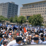 Police officers stand near demonstrators taking part in a protest over the freezing of deposits by some rural-based banks, in Zhengzhou, Henan province, China May 23, 2022, in this screengrab taken from a video obtained by Reuters. Handout via REUTERS
